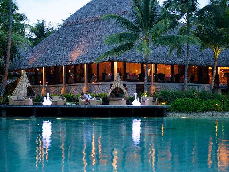 Außenbereich des InterContinental Bora Bora Resort and Thalasso Spa mit Paar auf der Terrasse und Wasser im Vordergrund