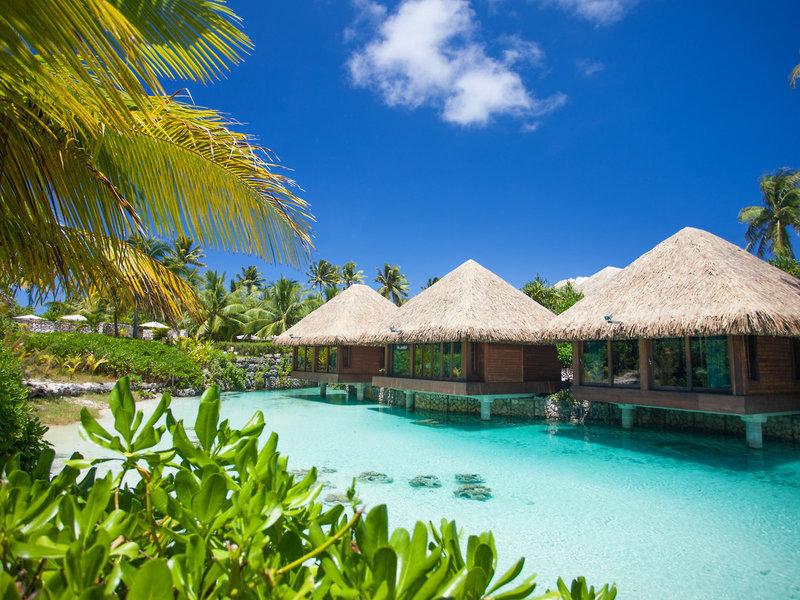 Drei Wasserbungalows des InterContinental Bora Bora Resorts mit blauem Wasser und grüner Vegetation.