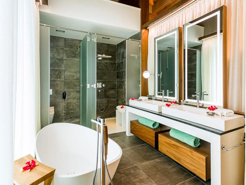 Ein elegantes Badezimmer im InterContinental Bora Bora Resort mit Badewanne, Dusche und zwei Waschbecken.