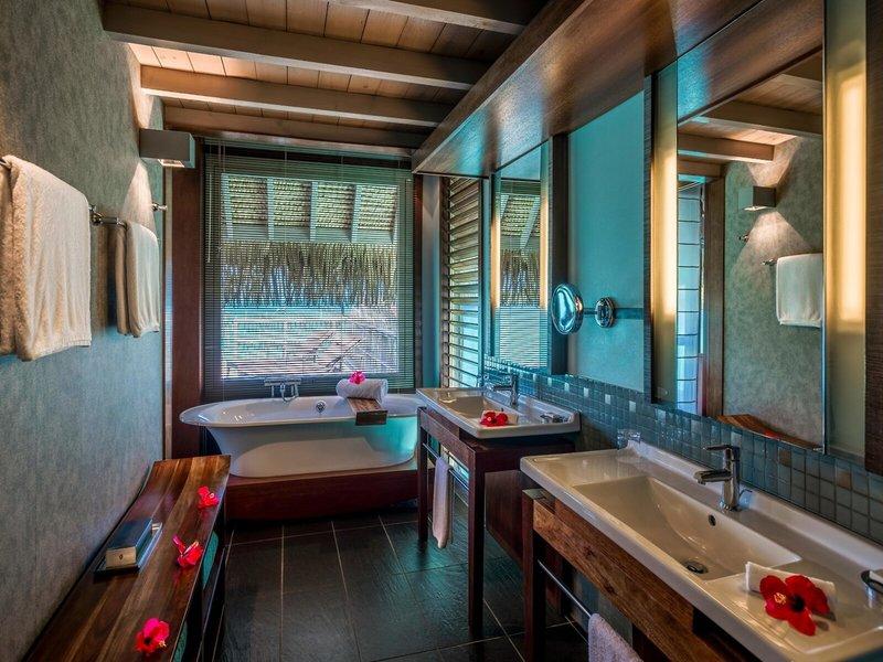 Luxuriöses Badezimmer im InterContinental Bora Bora mit Badewanne, Waschbecken und Fenstern.