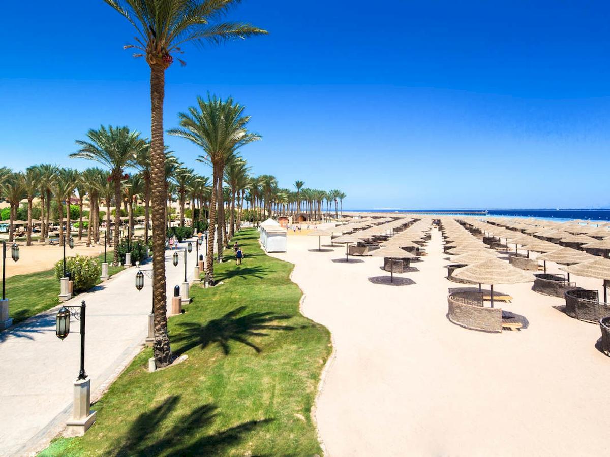 Luftaufnahme des Grand Makadi Hotels am Strand mit Palmen und Sonnenschirmen