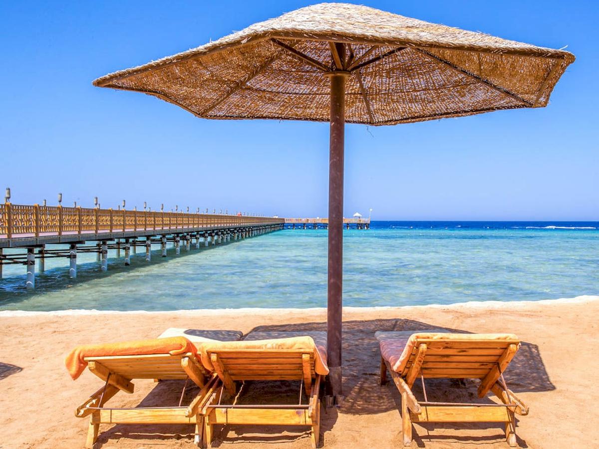 Strand mit Sonnenschirm und Liegen am Grand Makadi Hotel.
