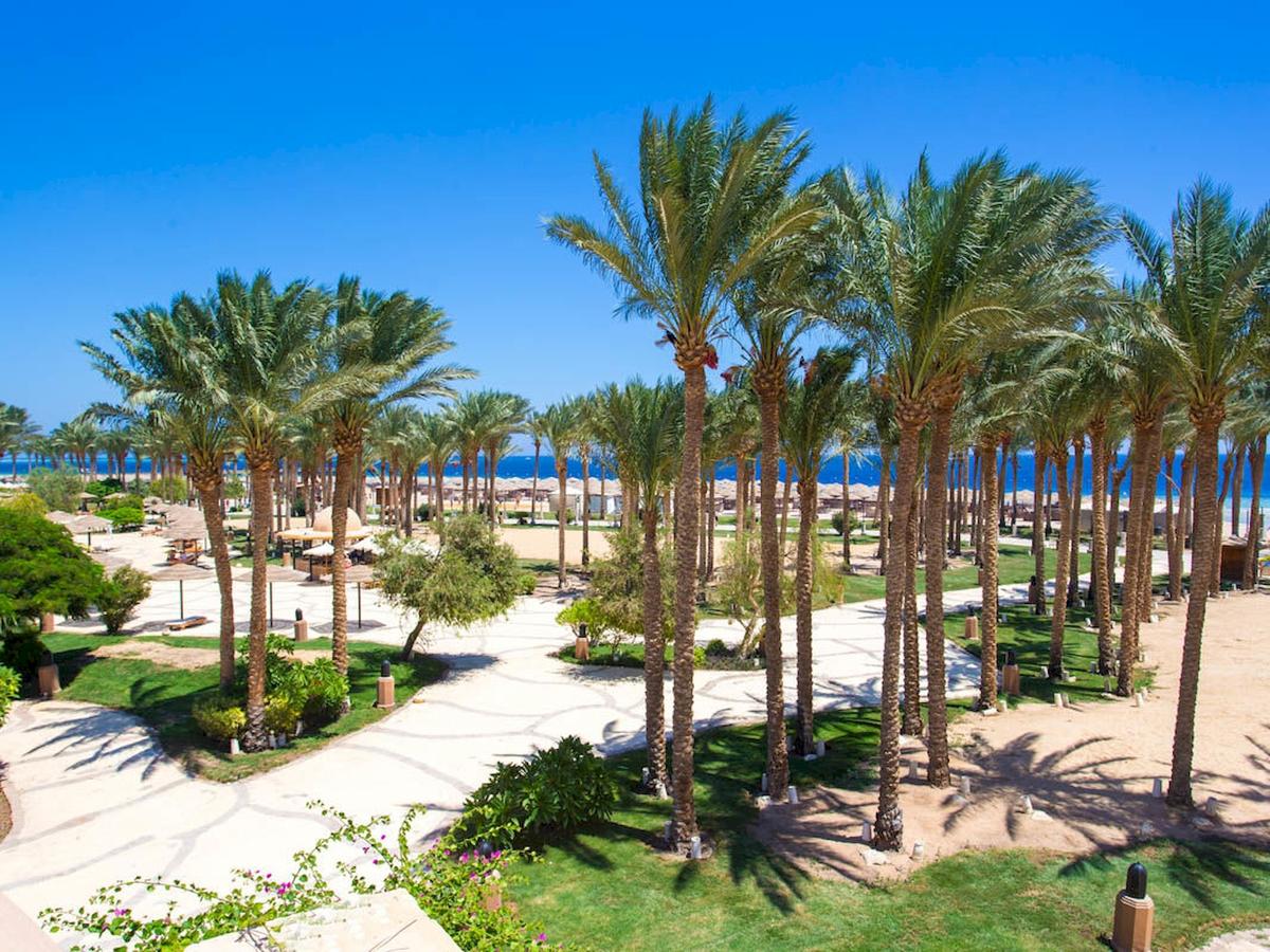 Tropische Anlage des Grand Makadi Hotels mit Palmen und Blick auf das Meer.