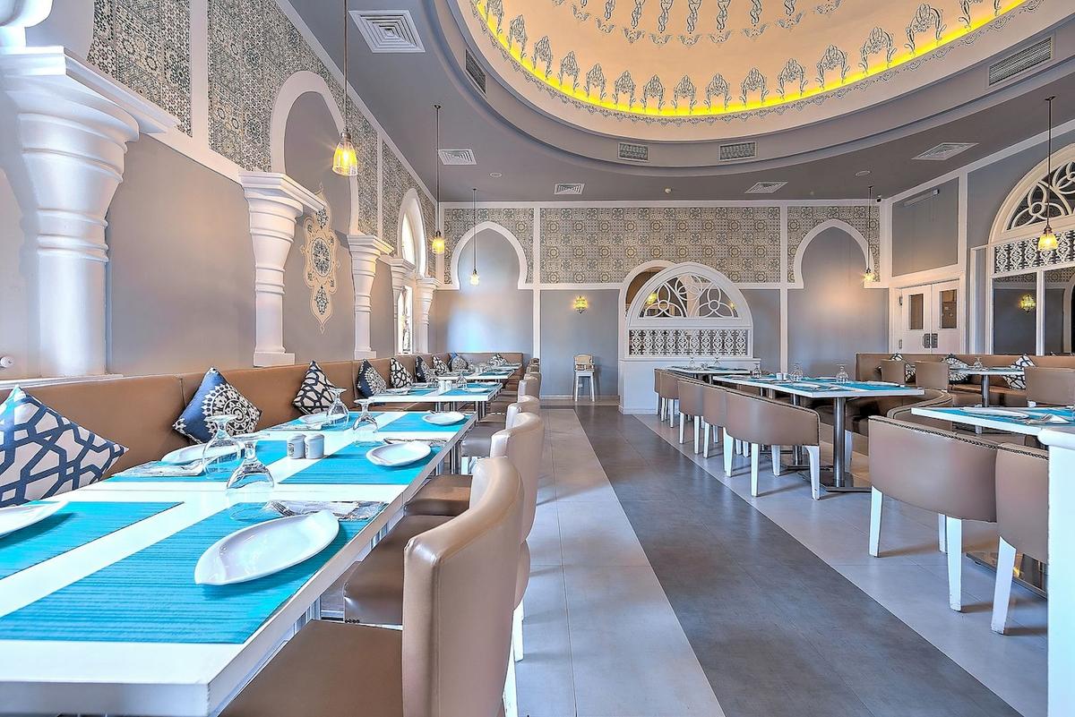 Innenbereich des Grand Makadi Hotels, Restaurantbereich mit gedeckten Tischen und Stühlen.