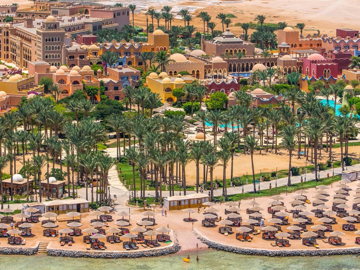 Luftaufnahme des Grand Makadi Hotels mit vielen bunten Gebäuden und Palmen