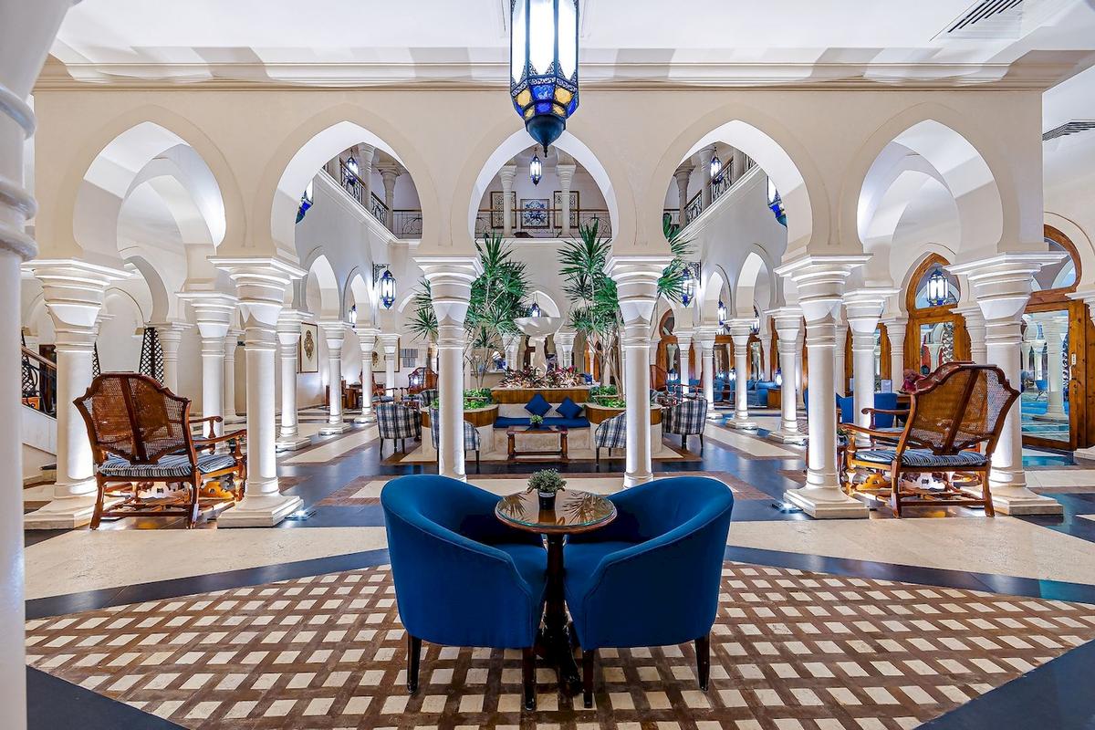 Innenansicht der Lobby des Grand Makadi Hotels mit blauen Sesseln und weißen Säulen