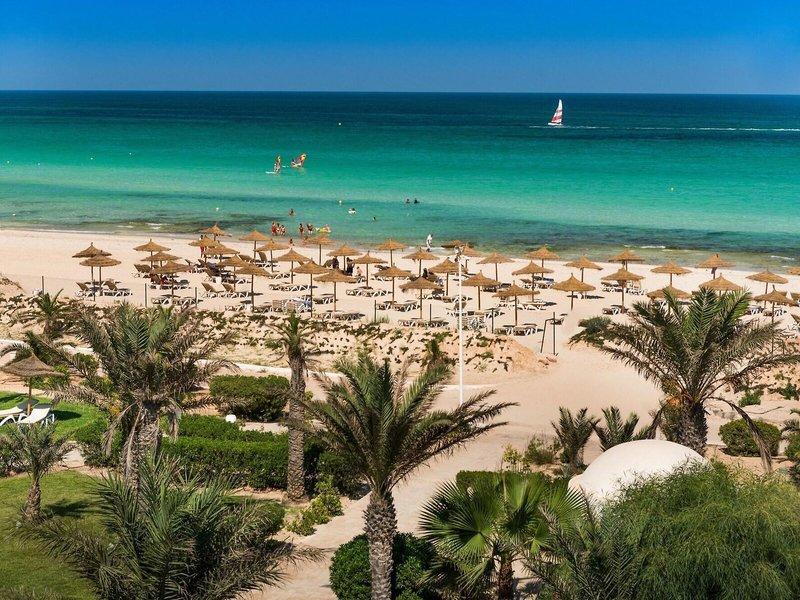 Strand mit Palmen und Sonnenhuten im Iliade Djerba von Magic Hotels