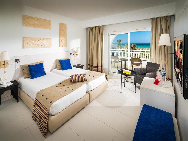 Hotelzimmer im Iliade Djerba by Magic Hotels mit zwei Betten, Balkon und Meerblick.