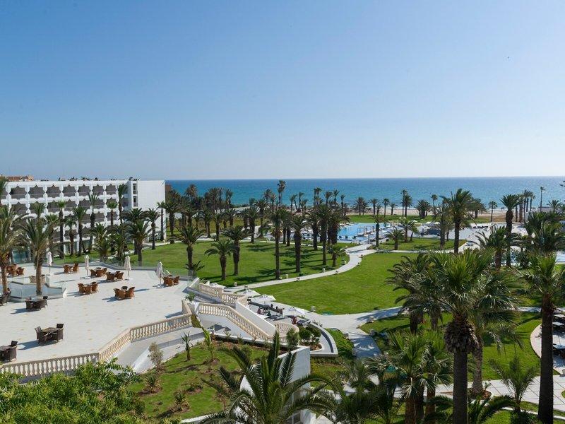 Außenansicht des JAZ Tour Khalef Hotels mit Palmen und Swimmingpools.
