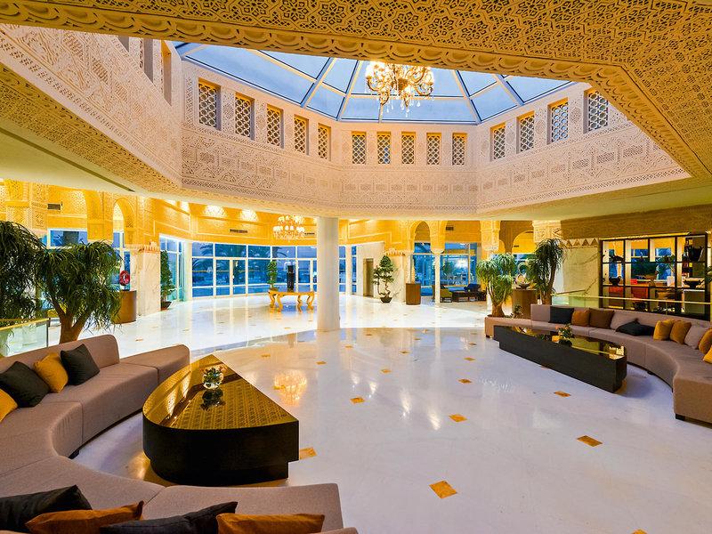 Lobby des JAZ Tour Khalef Hotels mit großen Sofas, goldenen Mustern auf dem Boden und einer großen Glaskuppel