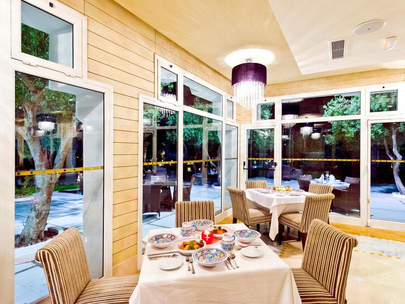 Innenansicht des Speisesaals im Jaz Tour Khalef Hotel mit großen Fenstern und moderner Einrichtung.