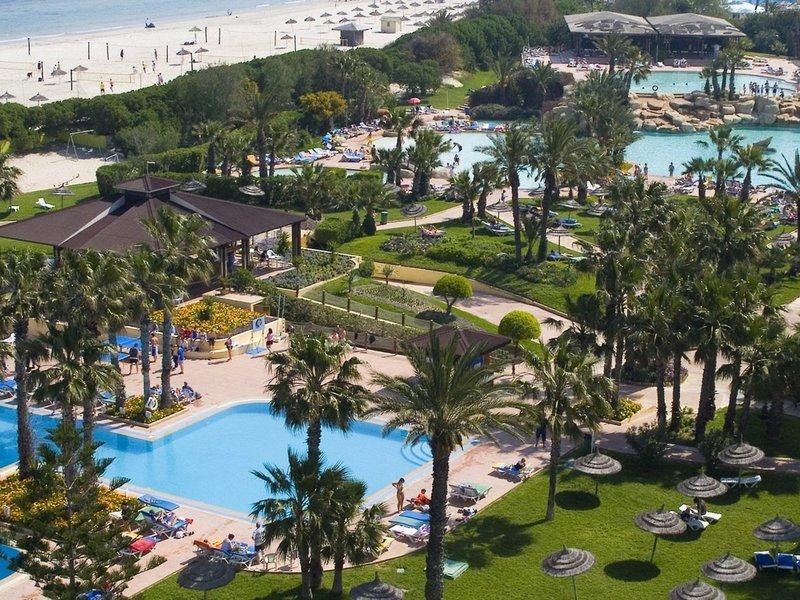 Luftaufnahme des Sahara Beach AquaPark Resorts mit mehreren Pools, Liegen und Palmen.