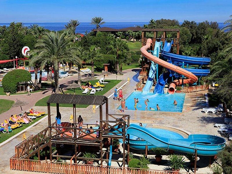 Ein Wasserpark mit Rutschen und Pool, viele Gäste entspannen und spielen.