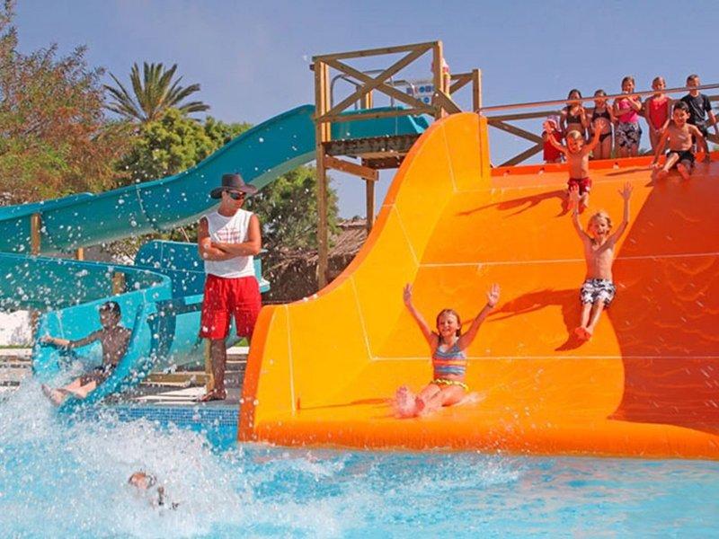 Kinder und Erwachsene genießen die Wasserrutsche im Sahara Beach AquaPark Resort.