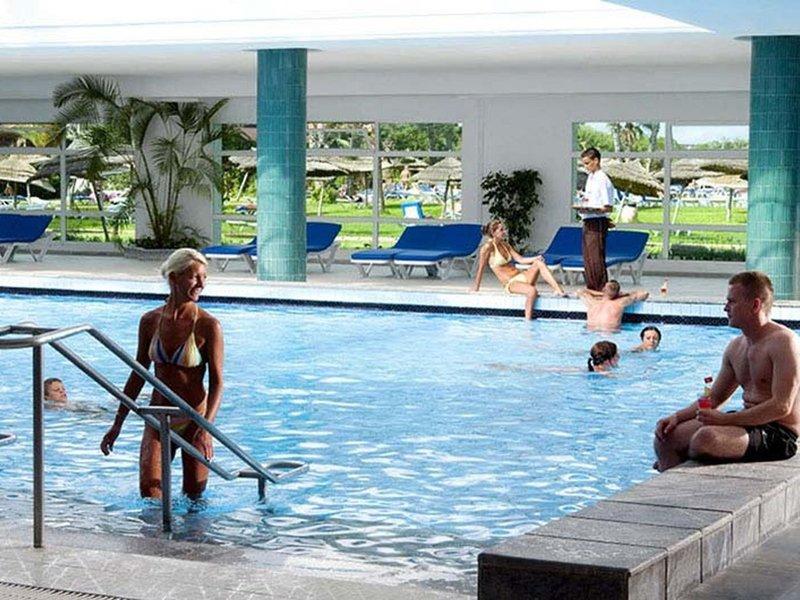 Innenpool des Sahara Beach AquaPark Resorts mit mehreren Gästen, die schwimmen und entspannen.