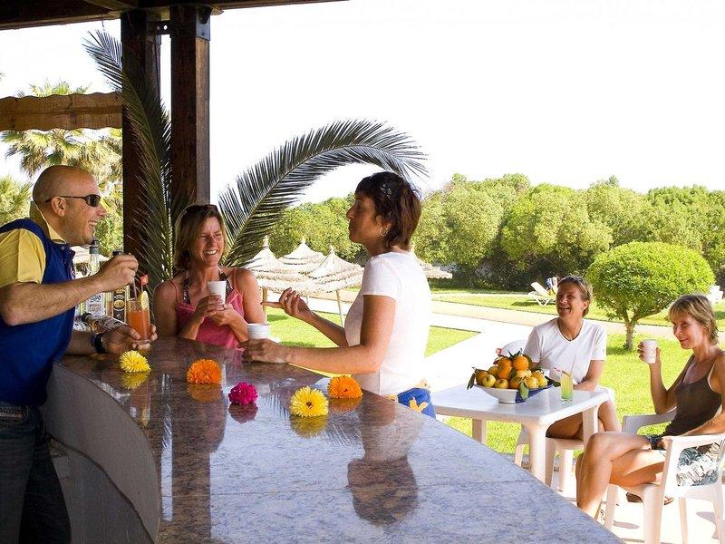 Freude und Unterhaltung auf der Terrasse des Sahara Beach AquaPark Resorts mit Gästen und Getränken.