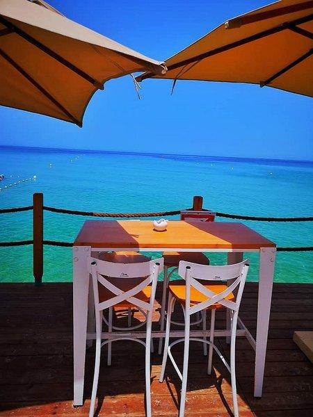 Terrasse des Sahara Beach AquaPark Resorts mit Tisch, Stühlen und Meerblick