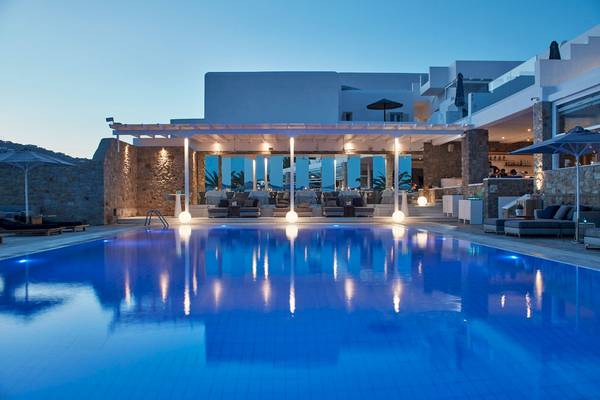 Außenbereich des Myconian Ambassador Hotels mit Swimmingpool und Loungemöbeln bei Nacht