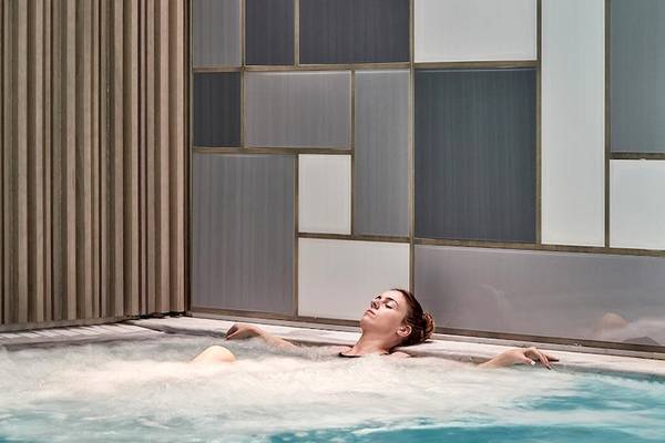 Eine Frau genießt ein entspannendes Bad im Schwimmbad des Myconian Ambassador Relais & Chateaux.