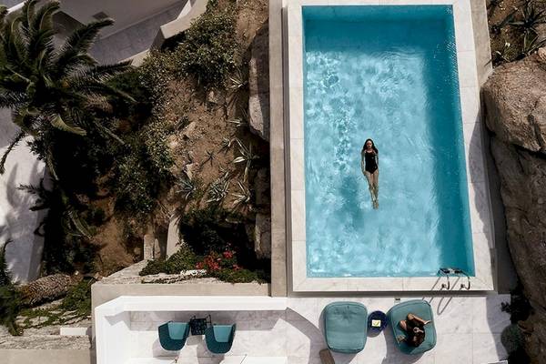 Ein Schwimmbad im Myconian Ambassador Hotel mit einer Frau im Wasser.