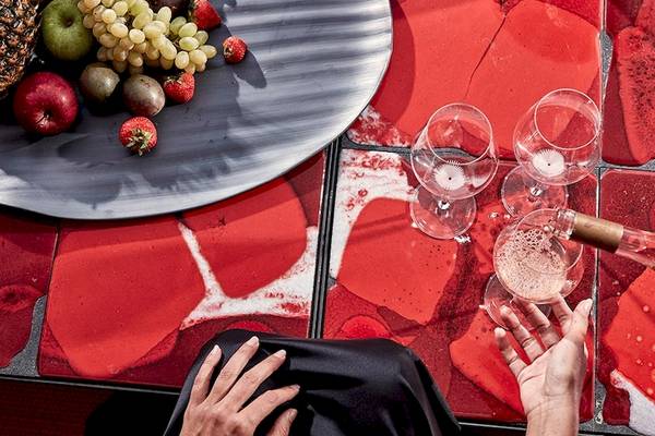 Frühstück im Bett im Myconian Ambassador Relais & Chateaux mit Früchten und Sekt auf rotem Tisch