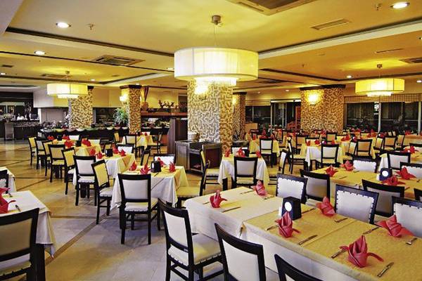 Innenansicht des Restaurants im Hotel Fun&Sun Smart Hane mit gedeckten Tischen und gelben Tischdecken.