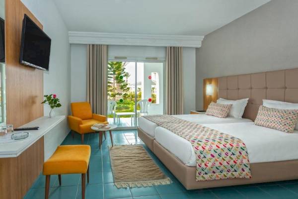 Zimmer im Djerba Holiday Beach Hotel mit zwei Betten, Fernseher und Balkon.