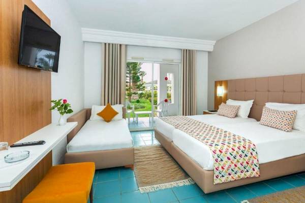 Djerba Holiday Beach Hotelzimmer mit zwei Betten, Fernseher und Gartenblick.