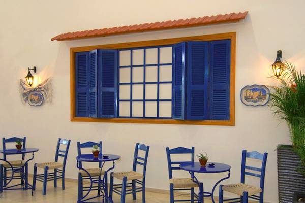 Innenbereich des Cafés im Irene Palace Beach Resort mit blauen Tischen und Stühlen.
