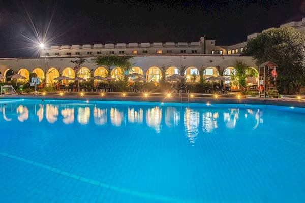 Nachtansicht des Irene Palace Beach Resorts mit großem Pool und beleuchteten Gebäuden