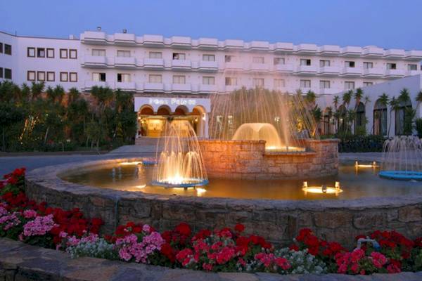 Eingang des Irene Palace Beach Resorts mit Springbrunnen und Blumenbeet.