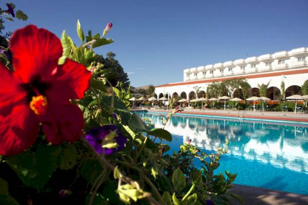 Ein Pool des Irene Palace Beach Resorts mit einer roten Blüte im Vordergrund.