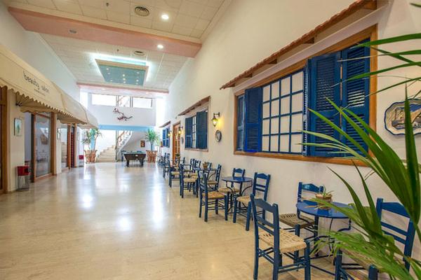 Innenbereich des Irene Palace Beach Resorts mit blauen Stühlen und Tischen.