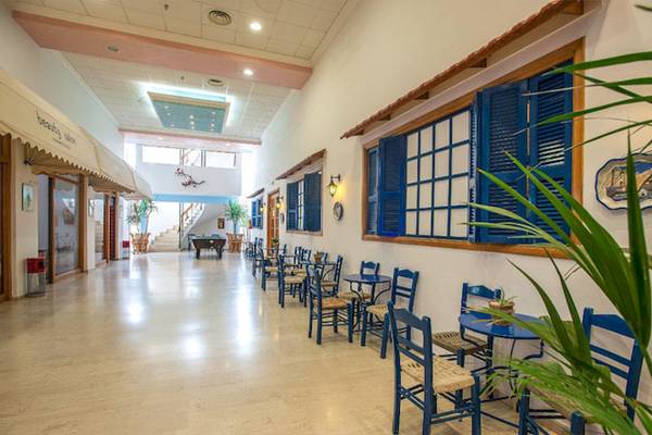 Innenbereich des Irene Palace Beach Resorts mit blauen Stühlen und Tischen.
