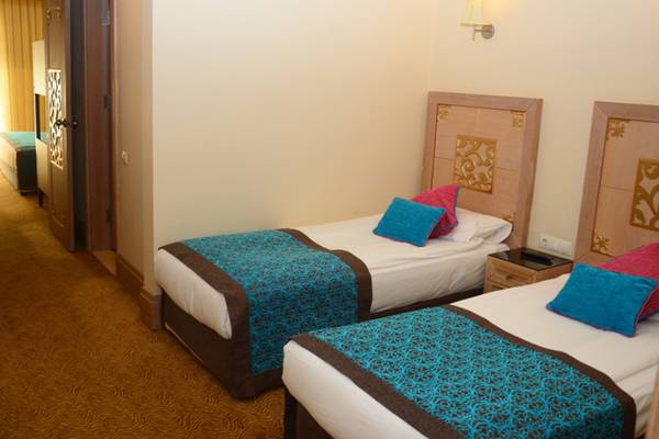 Doppelzimmer im Crystal Deluxe Resort & Spa mit zwei Betten, blauen Decken und Kopfkissen.