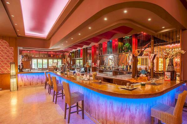 Bar im Irene Palace Beach Resort Hotel mit blauen Lichtern und Holztheke.