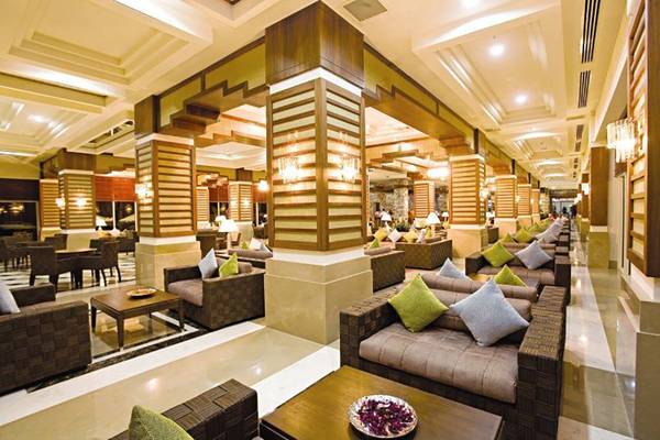 Lobbybereich des Crystal Deluxe Resort & Spa mit Sofas, Tischen und Beleuchtung.