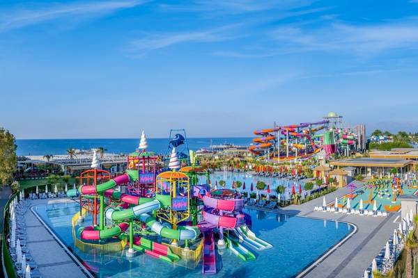 Außenansicht des Delphin Palace Wasserparks mit bunten Wasserrutschen und einem großen Pool.