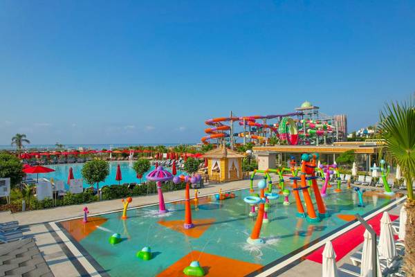 Außenansicht des Delphin Palace Wasserparks mit bunten Wasserrutschen und einem großen Pool.