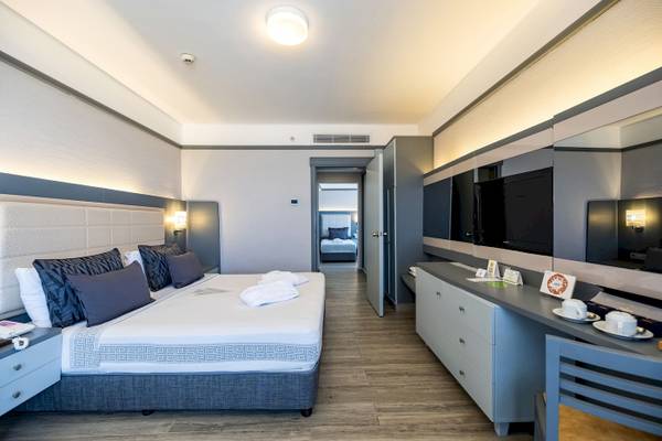 Vonresort Golden Coast Hotelzimmer mit großem Bett, Schränken und Fernseher.