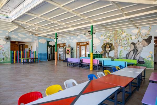 Kinderspielplatz im VONRESORT Golden Coast mit bunten Bänken und Tiermalereien an der Wand.