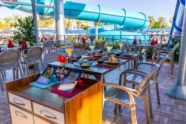 Terrasse im VONRESORT Golden Coast mit einer Wasserrutsche im Hintergrund.