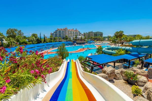 Wasserpark im VONRESORT Golden Coast mit bunter Rutsche und blauen Sonnenschirmen