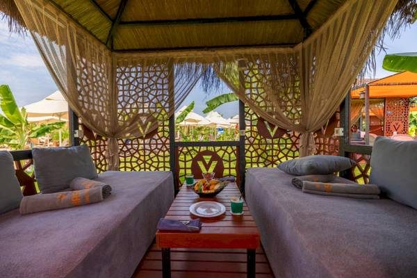 Lounge-Bereich im VONRESORT Golden Coast mit zwei Betten, Kissen und einem Tisch mit Obst.