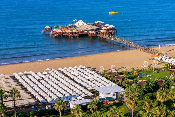 Luftaufnahme des VONRESORT Golden Coast am Strand mit vielen Sonnenschirmen und Palmen