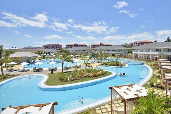 Luftaufnahme des Paradisus Princesa del Mar Resort & Spa mit großen Swimmingpools, Liegestühlen und Sonnenschirmen.