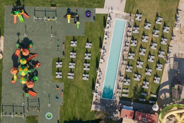 Luftaufnahme des Georgioupolis Resort Aquapark & SPA mit Wasserrutsche, Spielplatz und Sonnenliegen.