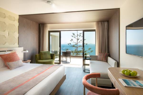 Mitsis Summer Palace Hotelzimmer mit Meerblick, Bett, Schreibtisch, Sofa und Terrasse.