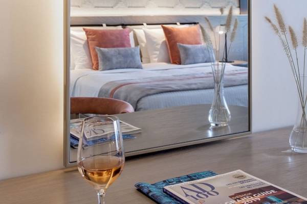 Mitsis Summer Palace Hotelzimmer mit Spiegel und Bett im Hintergrund.