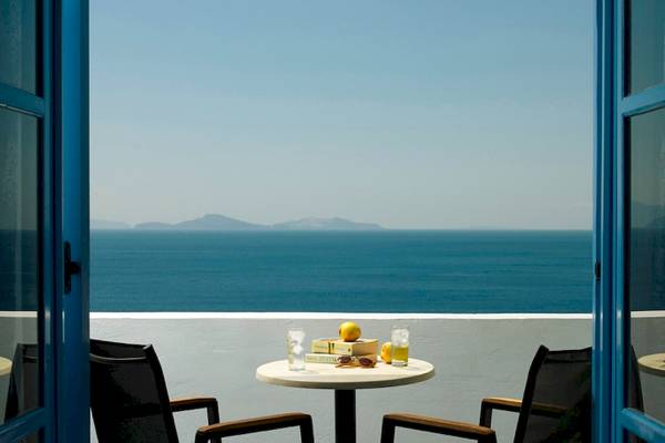 Balkon im Mitsis Summer Palace Hotel mit Blick auf das Meer und zwei Stühlen.